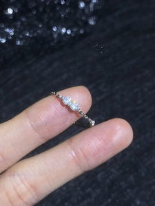Close-up of minimalist silver band ring with twin round moissanite stones on finger
