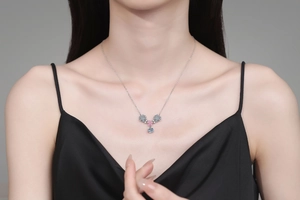 Detail of 925 sterling silver necklace featuring flower pendant with pink and blue stones