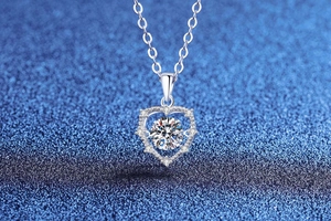 Macro shot of S925 silver heart pendant with sparkling moissanite on blue background