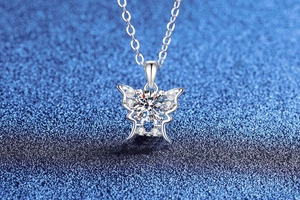 Macro detail of silver butterfly pendant featuring brilliant center moissanite and pearls
