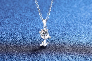 Macro detail of tulip moissanite pendant with silver petals and sparkling center stone