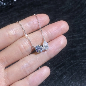 S925 sterling silver necklace with teardrop and round moissanite pendants in hand