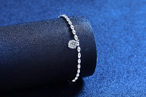 Macro shot of S925 silver bracelet featuring a rice-grain link with a moissanite stone