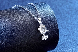 Macro view of S925 sterling silver tulip pendant with moissanite and pearls on a stand