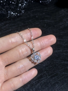 Macro view of sterling silver heart pendant with sparkling round cut moissanite center stone
