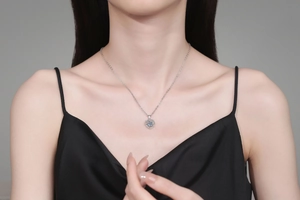 Close-up of S925 silver heart necklace with a blue moissanite stone on female neck