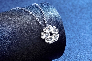 Macro shot of S925 sterling silver four-leaf clover heart pendant with moissanite