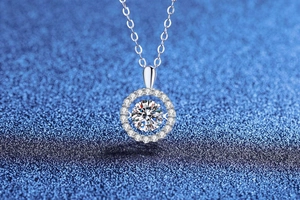 Dettaglio della collana con moissanite da 1ct D su catena d'argento e sfondo blu glitter