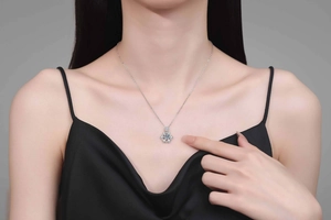 Close-up of snowflake pendant necklace with light blue moissanite on a female model