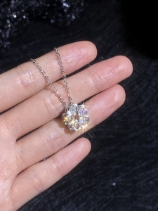 Macro shot of silver S925 clover pendant with sparkling diamonds held by hand