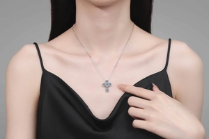 Dettaglio della collana con croce in Moissanite 3 carati indossata su abito di seta nera