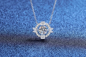 Macro del ciondolo in Moissanite d'argento con design a cuore su sfondo blu glitter