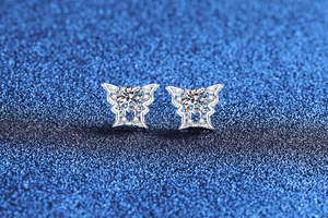 Detailed close-up of S925 silver butterfly earrings with moissanite and white pearls