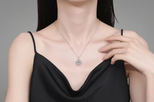 Close-up of S925 silver necklace with round moissanite pendant on female model