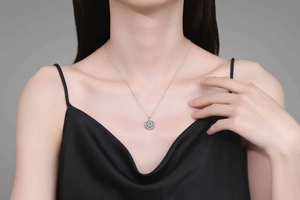 Close-up of S925 sterling silver snowflake necklace with blue center stone on model