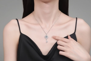 Gros plan détaillé du pendentif clé tournesol en argent 925 avec moissanite bleue sur modèle