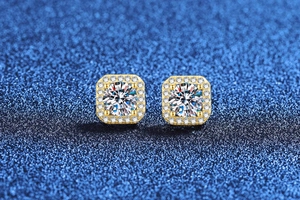 Gros plan sur les boucles d'oreilles en moissanite 1 carat avec monture halo dorée carrée