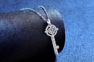 Vue macro d'un pendentif clé en argent avec moissanite étincelante sur support bleu