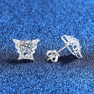 Sparkling butterfly silver earrings with moissanite and pearls on a dark background