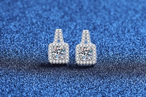 Macro shot of S925 silver square halo moissanite earrings on blue glitter background