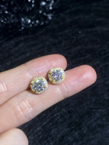 Close-up of gold-plated 925 silver stud earrings with a large round moissanite center