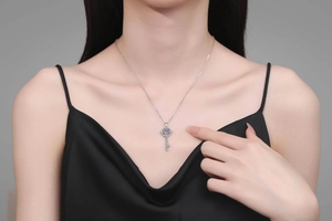 Gros plan d'un pendentif clé en argent sterling S925 porté par un mannequin féminin