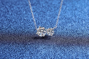 Macro shot of S925 silver necklace featuring double moissanite stones on starry background