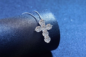 Macro shot of 4.8ct cross pendant with sparkling moissanite diamonds on silver necklace