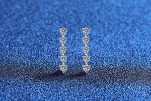 Macro detail of vertical S925 silver moissanite drop earrings with five round brilliant cut gems