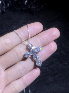 Macro shot of 4.8ct cross pendant with sparkling moissanite diamonds on S925 silver chain
