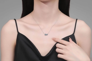 Detail shot of the 1.5 carat blue moissanite double flower necklace worn on a model