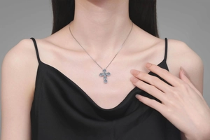 Detail of S925 silver cross necklace with 4.8ct blue moissanite stones on a model
