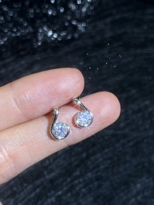Macro shot of S925 sterling silver musical note stud earrings with moissanite stones