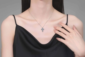 Nahaufnahme des S925 Silber Kreuzanhängers mit blauem Moissanit am Modelhals