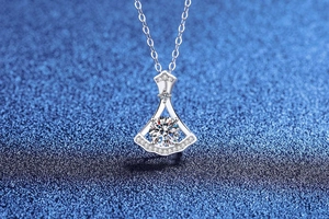 Macro detail of skirt-shaped pendant with round brilliant-cut moissanite and pave diamonds
