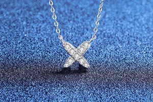 Detailed close-up of S925 silver X-shaped pendant with pavé-set moissanite diamonds
