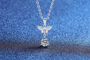 Close-up of silver butterfly necklace with marquise-cut zircon stones on blue texture