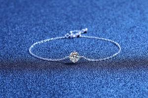 Macro detail of adjustable silver-toned link bracelet with a sparkling round solitaire stone