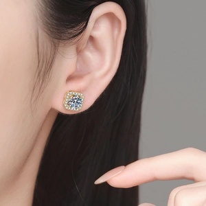 Boucles d'oreilles clous carrées en moissanite dorées 18 carats portées par un modèle