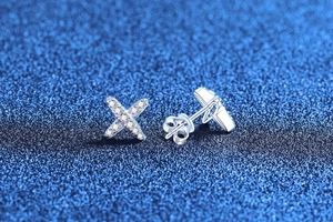 Macro view of sterling silver X-shaped stud earrings with pavé set cubic zirconia