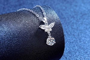 Detailed view of S925 silver necklace with moissanite butterfly pendant on blue display