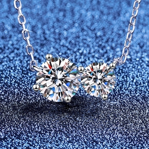 S925 sterling silver necklace with two round brilliant moissanite stones on blue texture