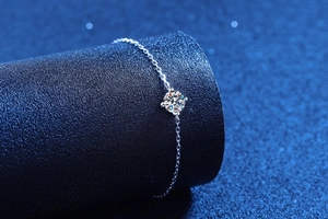 Detail showing classic four-prong setting for round moissanite on silver metal chain