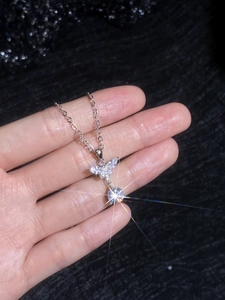 Macro detail of S925 silver butterfly pendant with large brilliant moissanite and pearls