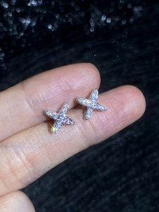 Close-up of star-shaped S925 silver stud earrings with pave-set sparkling moissanite