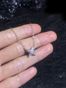 Macro shot of S925 silver necklace with sparkling crisscross pendant and pavé moissanite