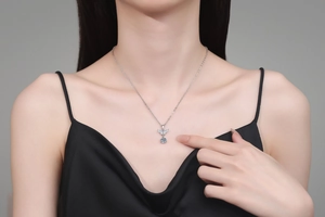 Detailed close-up of S925 silver butterfly wing necklace with light blue moissanite pendant