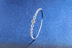 Dettaglio di un bracciale a fiore in argento con una brillante pietra centrale rotonda