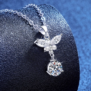 S925 sterling silver butterfly necklace with moissanite and pearls on a blue display