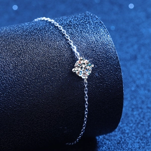 Elegant four-prong solitaire moissanite bracelet with adjustable silver chain and brilliant diamond